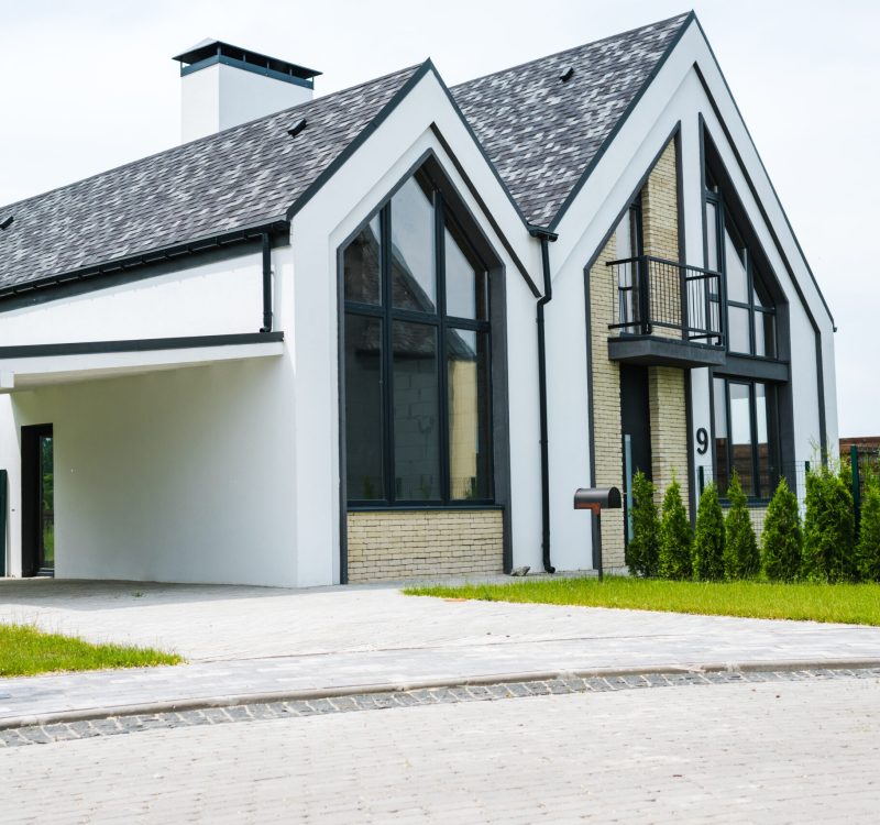 new modern and luxury home with windows and doors near green grass