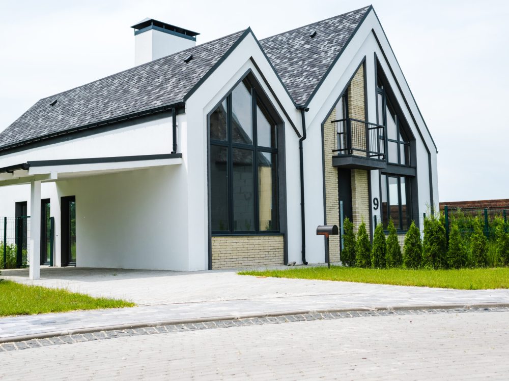 new modern and luxury home with windows and doors near green grass